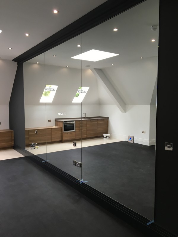 Frameless glass partition in loft conversion by Stratford glaziers